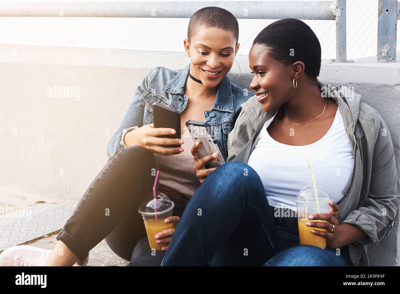 People Share The Juiciest Gossip They've Been Quietly Hiding 3 sharing juicy gossip all the time two young women in the city sitting down while laughing and holding their drinks reading through text messages 2K9FK9F